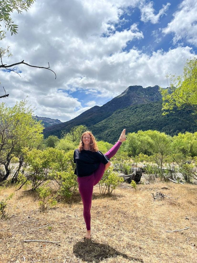Jazmin smiling in a standing balance in the mountains