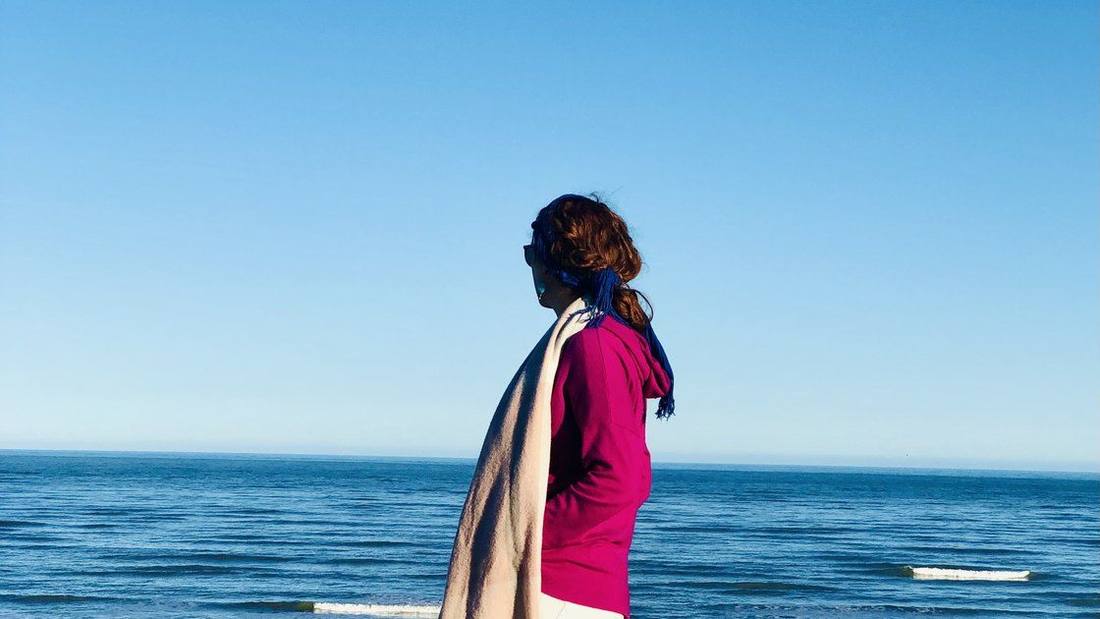 Jazmin standing at the shore, looking out to sea